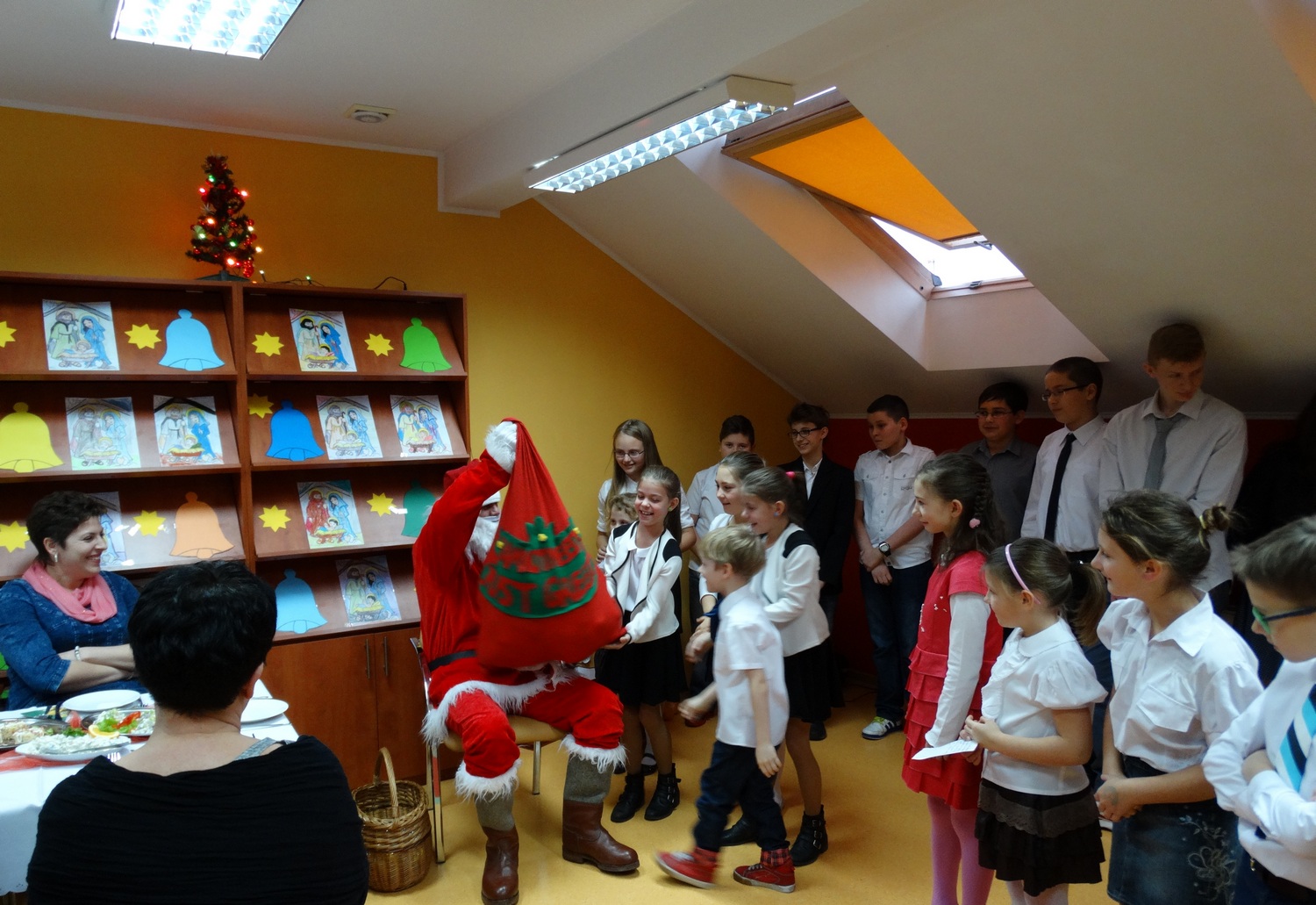 Wigilijne 2015: Zdjęcie przedstawia Świętego Mikołaja z workiem i obserwujące go dzieci.