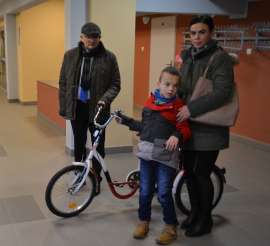 Przekazanie Rowerów Eco Textil_3 zdjęcie przedstawia: dwie dorosłe osoby i dziecko stojące przy rowerze