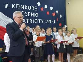 Konkurs piosenki w Grochowach_5:zdjęcie przedstawia: mężczyznę a za nim grupę dzieci