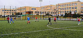 Orlik - boisko sportowe_1: Zdjęcie przedstawia dzieci na boisku na tle budynku szkoły.