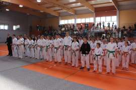 Mistrzostwa Oyama Karate w Kata_1 zdjęcie przedstawia: grupę zawodników ubranych w biale stroje stojących na sali
