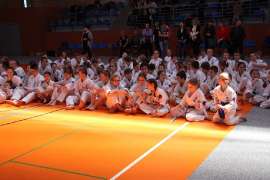 Mistrzostwa Oyama Karate w Kata_6 zdjęcie przedstawia: grupę zawodników w białych strojach siedzących na sali