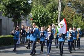 Przedszkolaki_26: Zdjęcie przedstawia ludzi ubranych na niebiesko. Jeden z nich trzyma flagę.