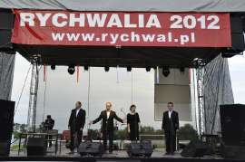 Rychwalia 2012: Zdjęcie przedstawia czterech mężczyzn i jedną kobietę stojących na scenie.