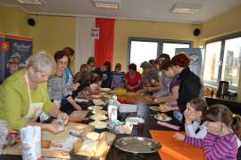 UTW Rychwał: zdjęcie przedstawia grupę  ludzi którzy gotują