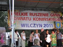Wilczyn Ruszenie Powiatu: Zdjęcie przedstawia grupę ludzi na scenie z nagrodami.