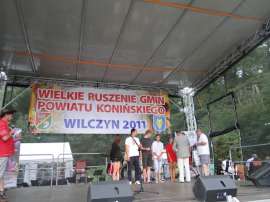 Wilczyn Ruszenie Powiatu: Zdjęcie przedstawia moment wręczania medali uczestnikom imprezy na scenie.
