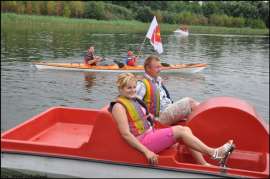 Wilczyn Ruszenie Powiatu: Zdjęcie przedstawia ludzi na kajaku i rowerku wodnym płynących po jeziorze.