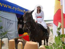 Wilczyn Ruszenie Powiatu: Zdjęcie przedstawia kobietę na koniu za drewnianym płotem.