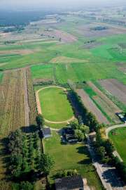 Z lotu ptaka: Zdjęcia przedstawia pola uprawne i stadion miejski widziane z wysokości.